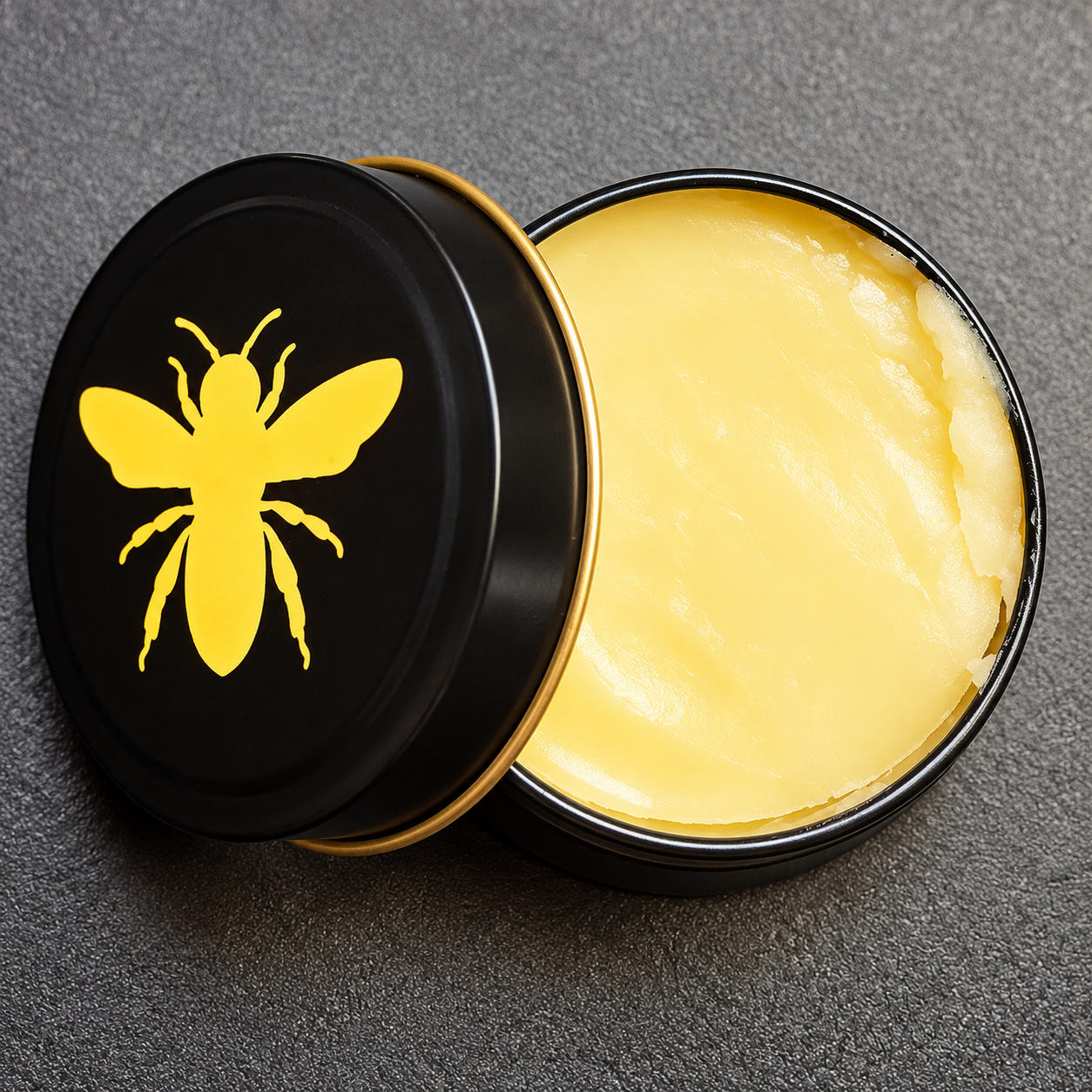 Beez in the Wax handcrafted balm in a black tin with a gold bee